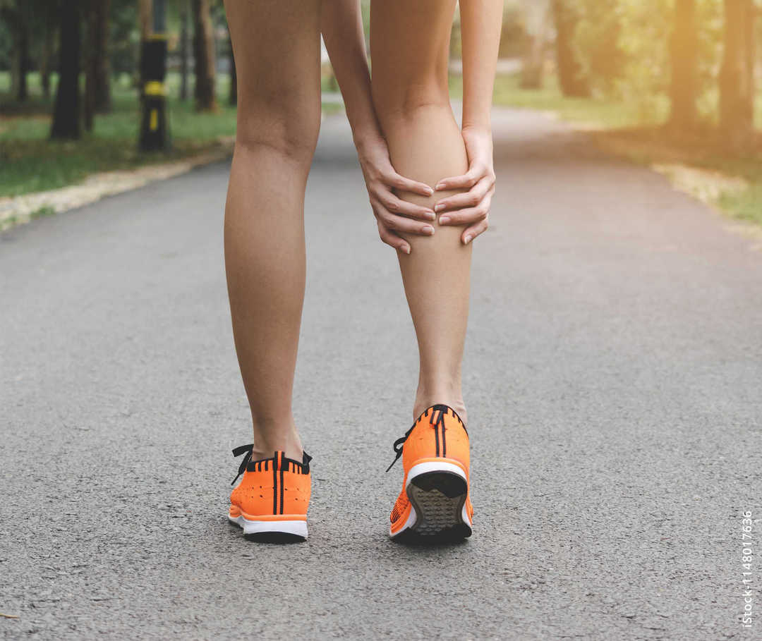 MS & ich: Eine Joggerin hält sich die rechte Wade MS & ich: Eine Joggerin hält sich die rechte Wade